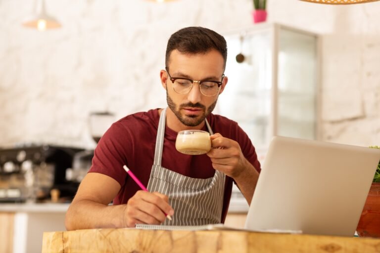 Busy businessman is drinking cappuccino and working